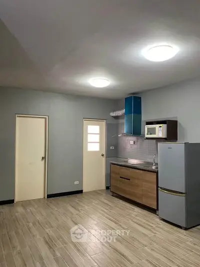 Modern kitchen with sleek cabinetry and stainless steel appliances in a spacious apartment.