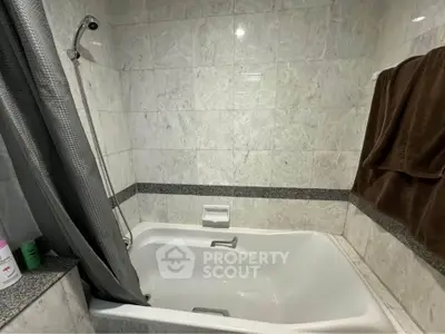 Elegant bathroom with marble tiles and a bathtub, perfect for relaxation.