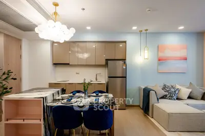 Modern open-plan living room and kitchen with stylish decor and elegant lighting.
