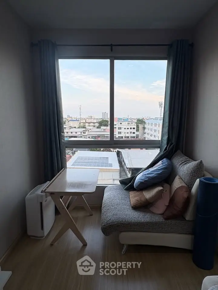 Cozy living room with city view, featuring a stylish sofa and modern decor.