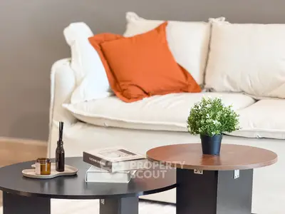 Stylish living room with cozy sofa and modern coffee tables, perfect for relaxation.