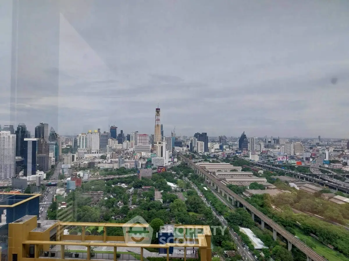 Stunning cityscape view from high-rise building showcasing urban skyline and greenery.