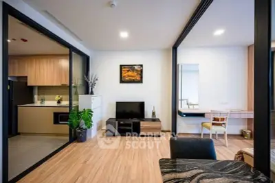 Modern living room with open layout and stylish decor, featuring a cozy seating area and sleek kitchen.