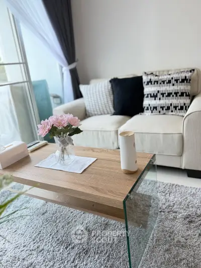 Chic modern living room with stylish sofa, glass coffee table, and elegant decor in a bright, airy space.