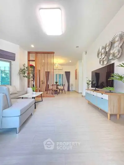 Spacious modern living room with stylish decor and open layout leading to dining area.
