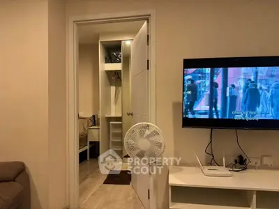 Cozy living room with open closet and wall-mounted TV, perfect for modern living.