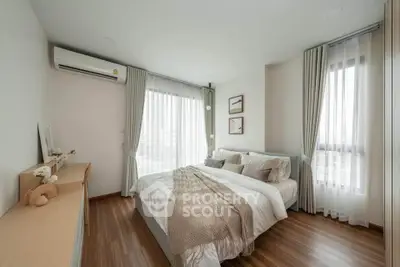 Elegant bedroom with modern decor and large windows offering natural light.