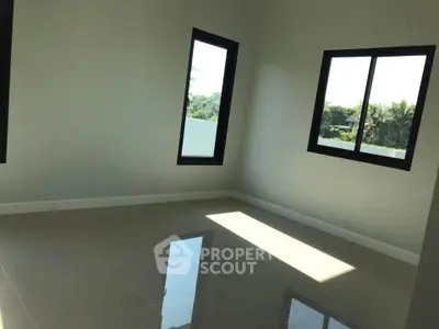 Spacious sunlit room with large windows and glossy tiled floor, perfect for customization.