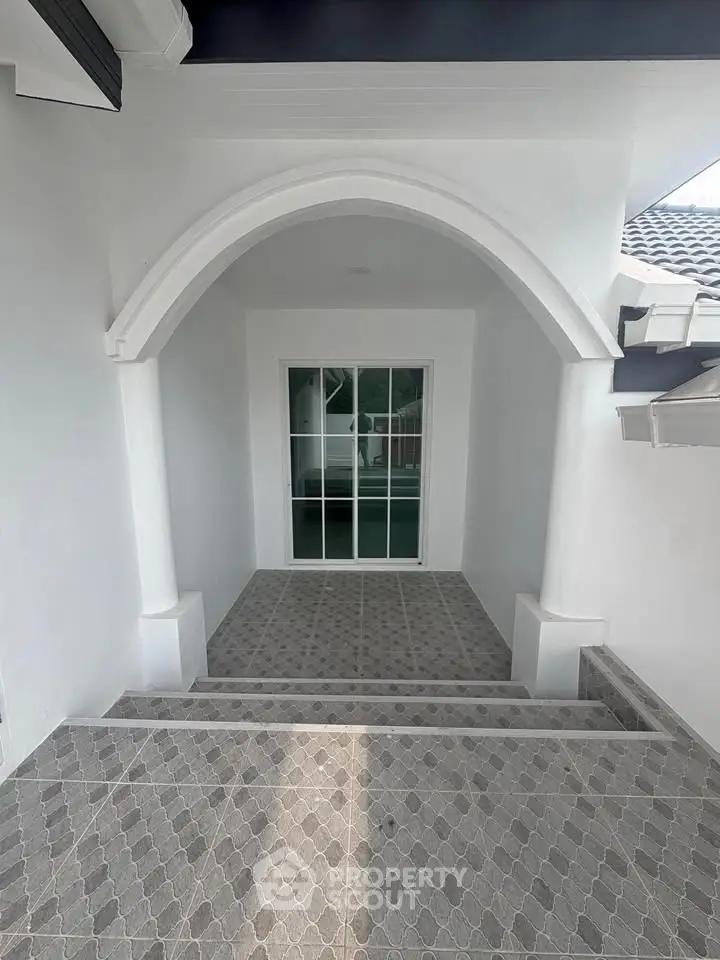 Elegant entrance with arched doorway and tiled steps in modern home