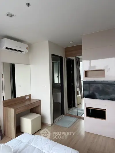 Modern bedroom with sleek design, featuring built-in TV and air conditioning, perfect for urban living.