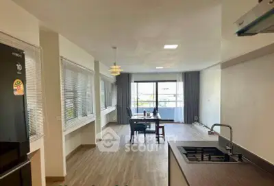 Spacious open-plan living and dining area with modern kitchen and large windows.