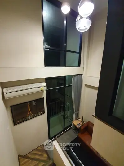 Modern loft-style living room with high ceilings and large windows