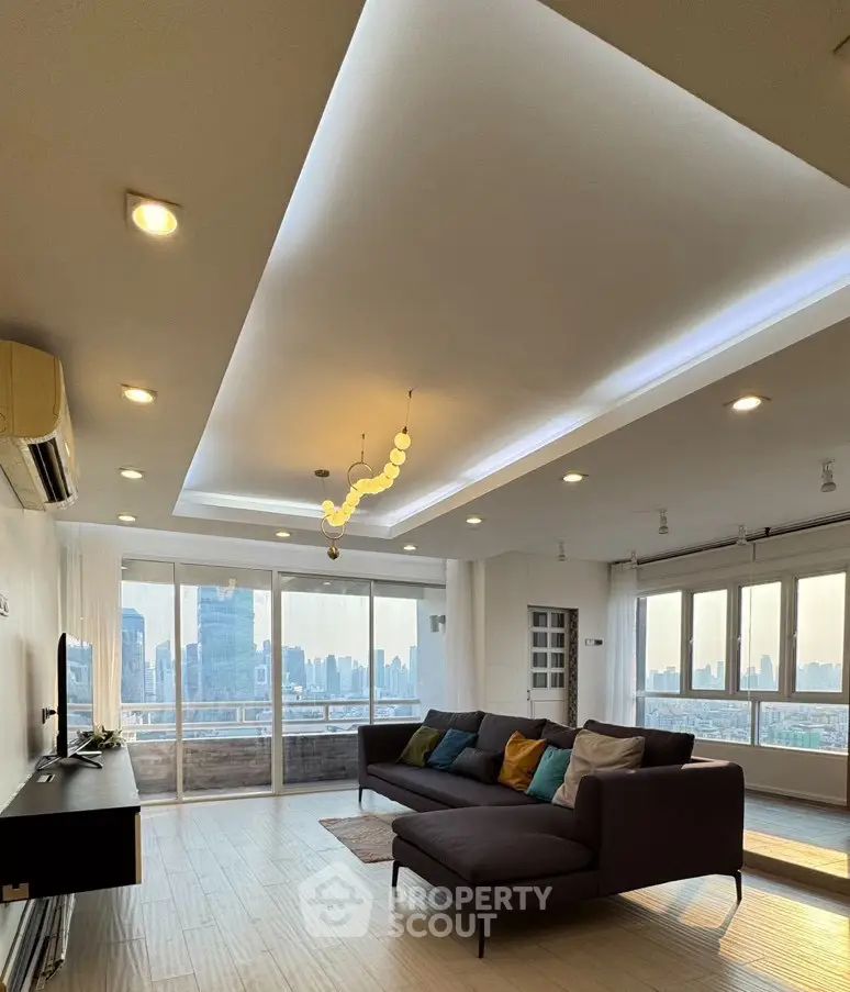 Spacious modern living room with stunning city skyline view and elegant lighting.