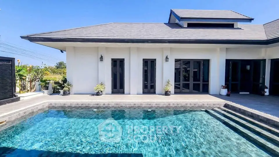 Luxurious modern villa with private pool and elegant architecture under clear blue sky.