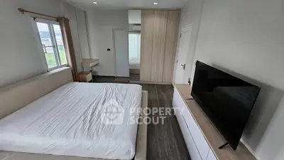 Modern bedroom with sleek design, large bed, and wall-mounted TV, perfect for relaxation.