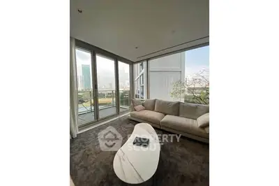 Spacious living room with large windows and modern sofa offering city views