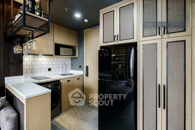 Modern compact kitchen with sleek appliances and stylish cabinetry in a contemporary apartment.