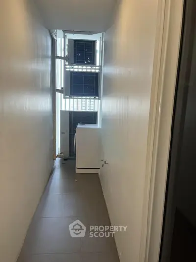 Compact utility area with washing machine and air conditioning units in narrow space.