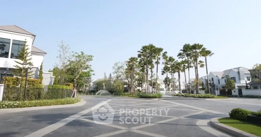 Luxurious residential community entrance with palm trees and modern homes