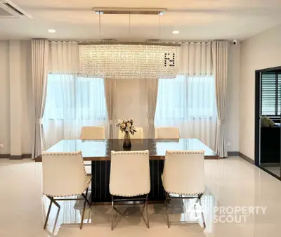 Elegant dining room with modern chandelier and stylish white chairs