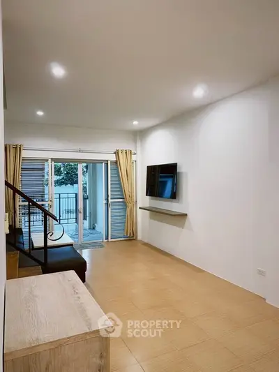 Spacious modern living room with balcony access and sleek design