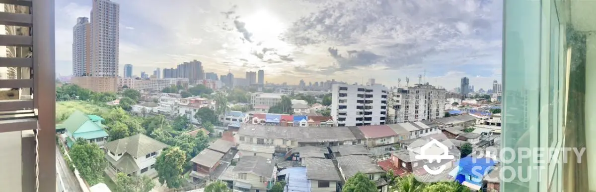 Panoramic cityscape view from a high-rise balcony showcasing urban skyline and residential area.