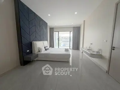 Spacious modern bedroom with elegant design and large windows for natural light.