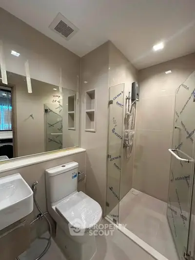 Modern bathroom with glass shower enclosure and sleek fixtures