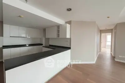 Modern kitchen with sleek cabinetry and open layout in a spacious apartment.