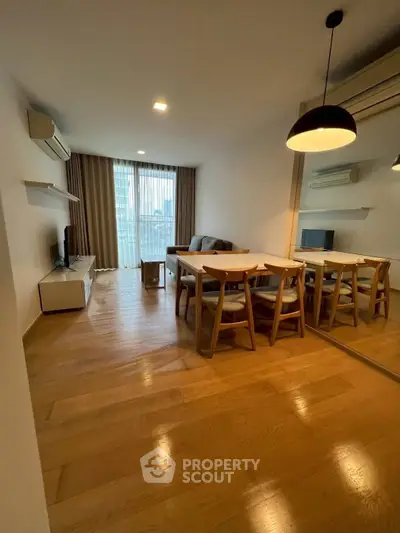 Spacious living room with modern furniture and large window offering natural light.