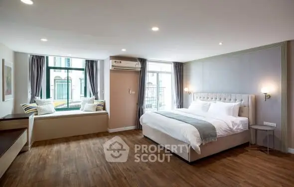 Spacious modern bedroom with elegant decor and large windows