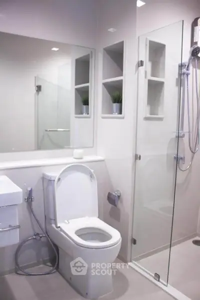 Modern bathroom with glass shower and sleek fixtures in a contemporary apartment.