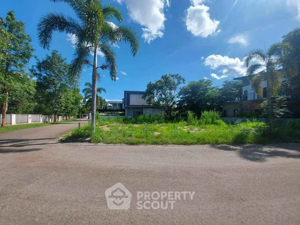 Stunning modern home with lush greenery and palm trees under a bright blue sky.
