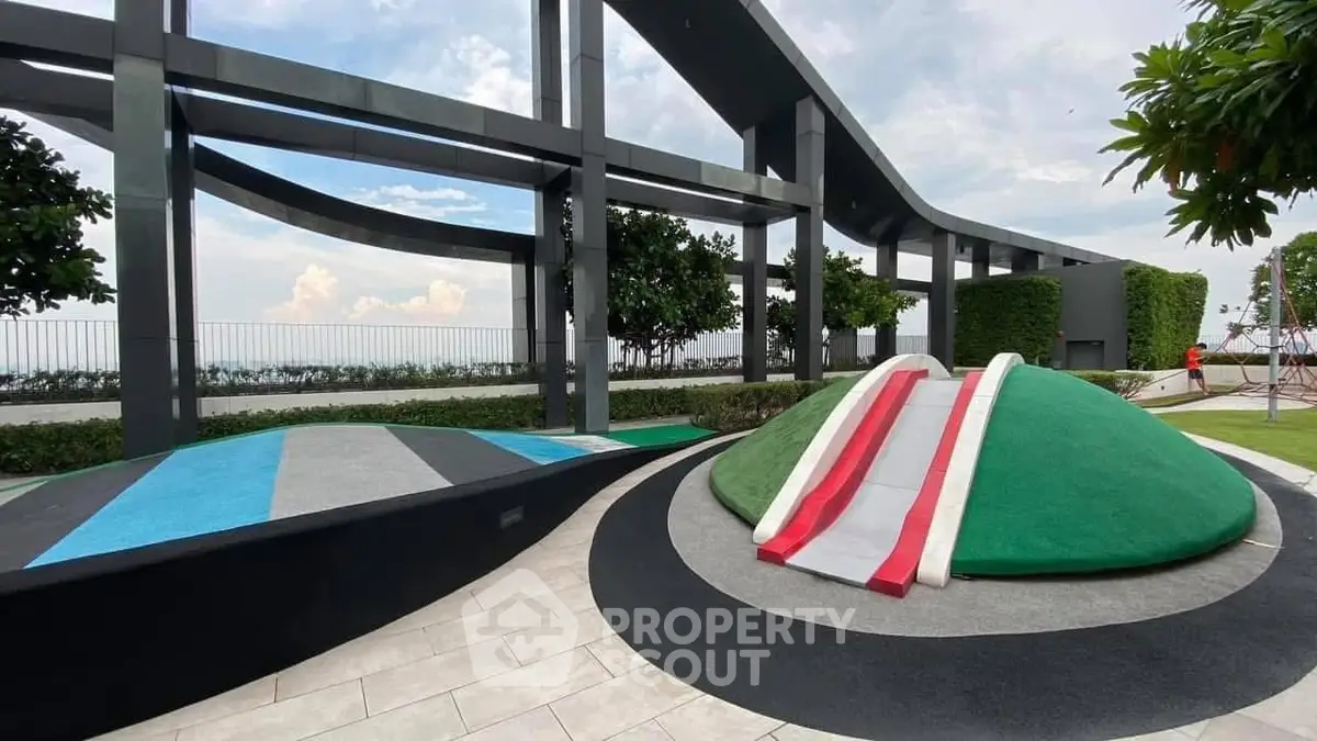Modern rooftop playground with slides and scenic views in urban setting.