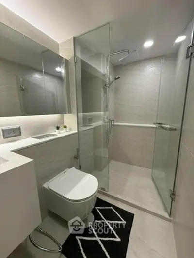 Modern bathroom with glass shower enclosure and sleek fixtures