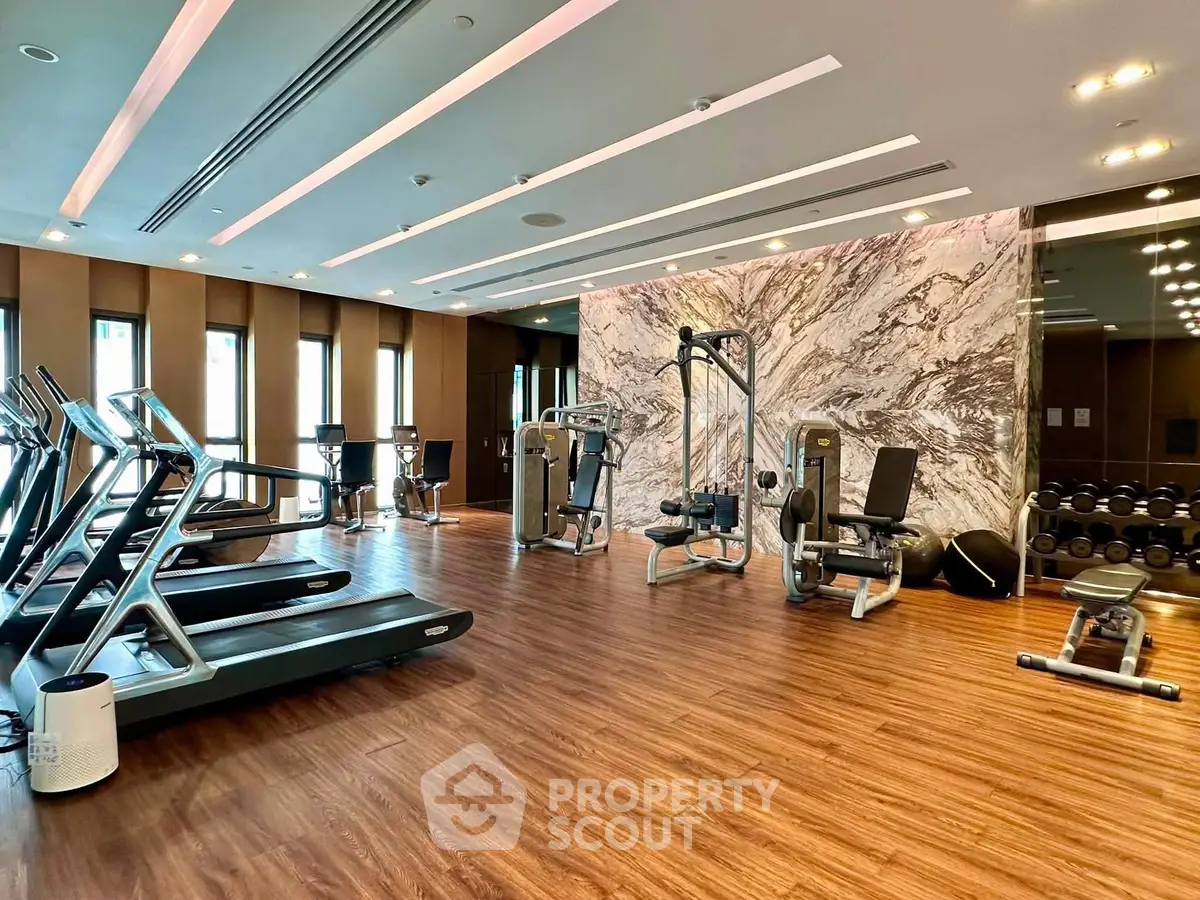 Luxurious gym with modern equipment and elegant design in upscale residential building.