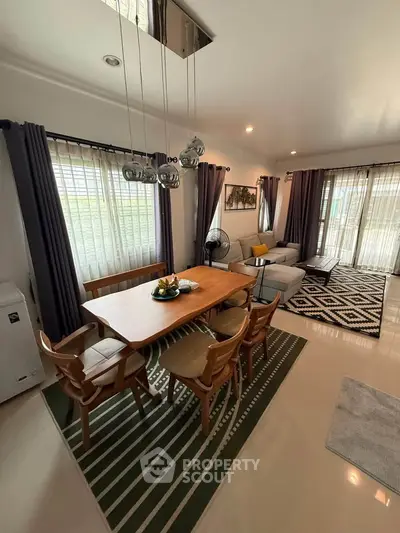 Spacious living room with modern dining area and stylish decor, perfect for family gatherings.