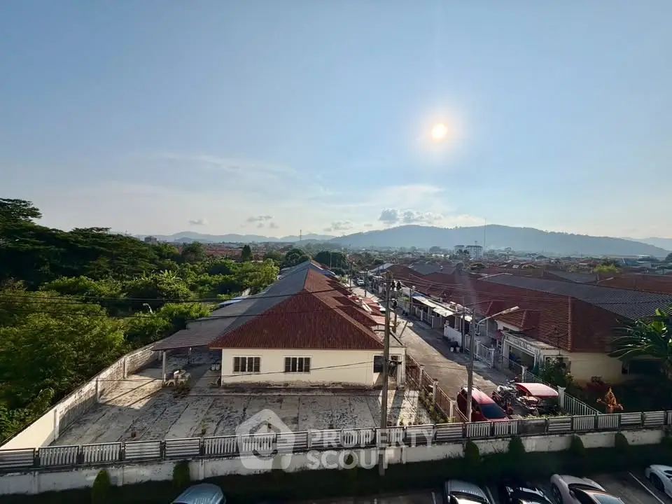 Scenic view of suburban neighborhood with mountains in the background under a clear blue sky.