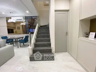 Modern living room with elegant staircase and dining area