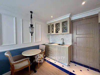 Charming kitchen with elegant cabinetry and cozy dining area in a stylish apartment.