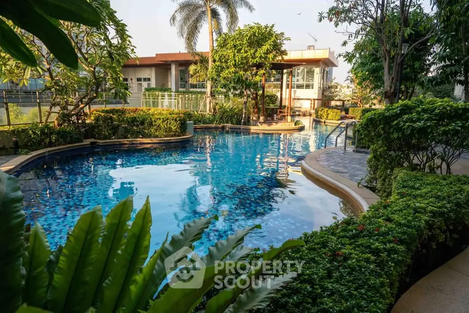 Luxurious residential pool surrounded by lush greenery and modern architecture.
