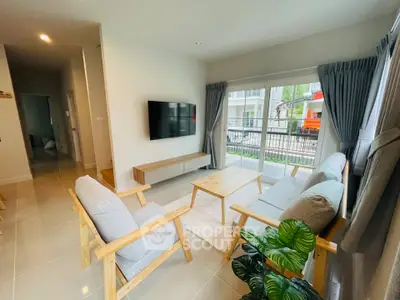Modern living room with natural light, stylish furniture, and a view of the garden through large windows.