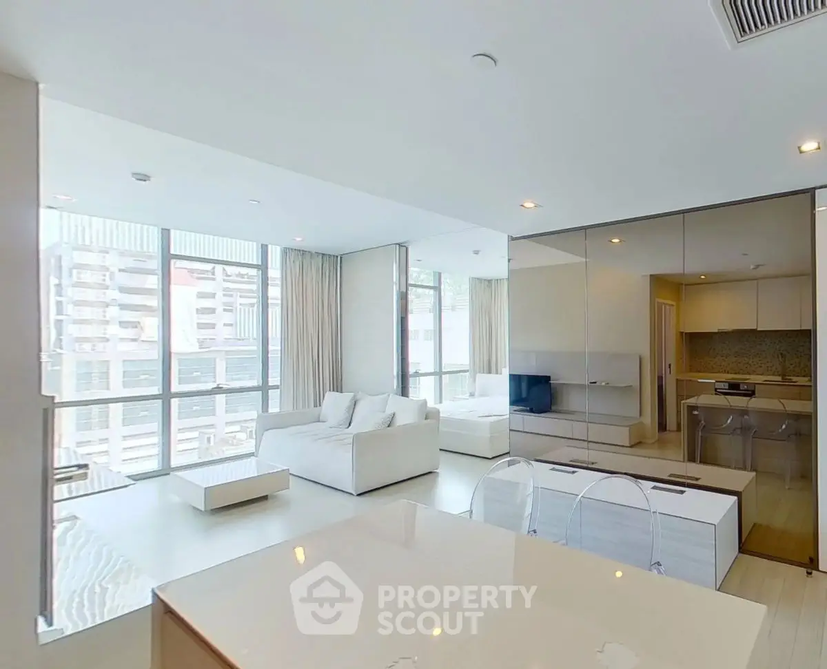 Modern open-plan living room with sleek kitchen and large windows