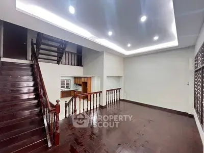 Spacious interior with wooden staircase and modern lighting, ideal for family living.