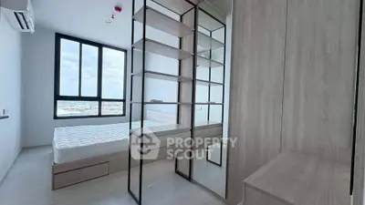 Modern bedroom with large windows and built-in storage, offering a bright and airy atmosphere.