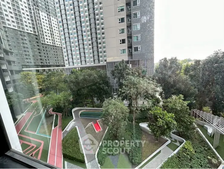 Stunning view of modern apartment complex with lush green garden and walking paths.