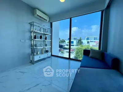 Modern living room with large window and sleek decor in a stylish home.