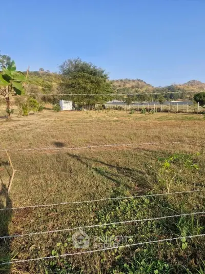 Expansive land with scenic views, perfect for development or agriculture, surrounded by lush greenery and hills.