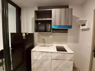 Modern compact kitchen with sleek cabinetry and built-in appliances in a stylish apartment.