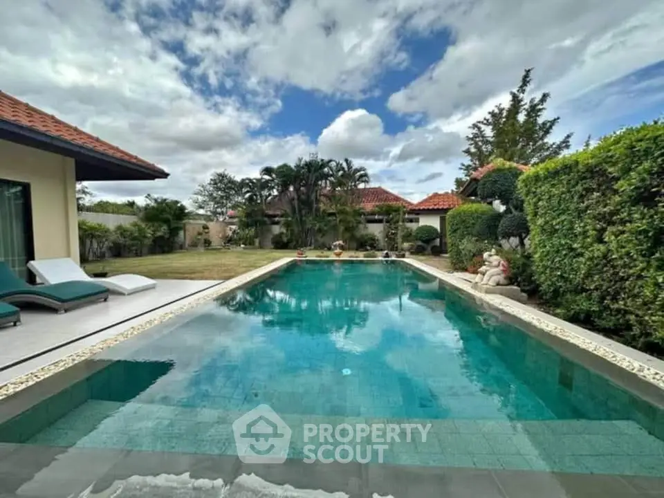Luxurious villa with private pool and lush garden under a vibrant sky.